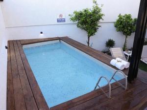 ein großes Schwimmbecken mit Holzterrasse und einem Schwimmbecken in der Unterkunft וילה Mandala אירוח&אירועים in Sājūr