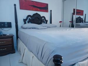 a bedroom with a large bed with white sheets at AZUL PUERTO Del MALECON in San Felipe de Puerto Plata
