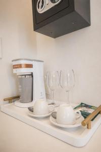 a counter with a coffee maker and wine glasses on it at Elsi Pousada in Búzios