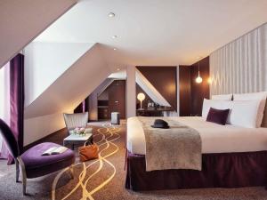 a hotel room with a bed and a chair at Mercure Paris Opera Garnier Hôtel & Spa in Paris +153 photos