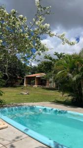 a blue swimming pool in front of a house at Pousada Floradas da Serra in Chapada dos Guimarães