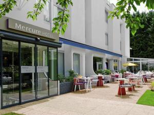 ein Hotel mit Tischen und Stühlen vor einem Gebäude in der Unterkunft Mercure Hotel Forbach Centre de Loisirs in Forbach
