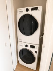 a microwave and a washer and dryer in a room at Lovely Brand New Suite in Sidney
