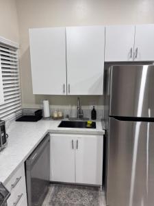 a kitchen with white cabinets and a stainless steel refrigerator at Private Studio, Near DT & Cal Expo, Free Parking in Sacramento