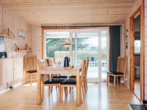 a dining room with a wooden table and chairs at 6 person holiday home in Tarm in Tarm