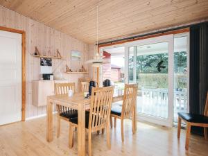 a dining room with a wooden table and chairs at 6 person holiday home in Tarm in Tarm
