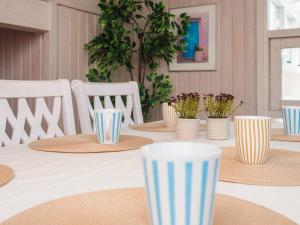 a table with straw hats and potted plants on it at 6 person holiday home in Ulfborg in Ulfborg +32 photos