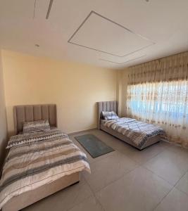 a bedroom with two beds and a window at مزرعة اننتارا in Amman