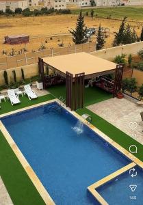an overhead view of a pool with a table and chairs at مزرعة اننتارا in Amman