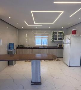 a kitchen with a table and a refrigerator at مزرعة اننتارا in Amman