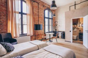 a room with two beds and a brick wall at Old Post Loft Apartments in Spremberg