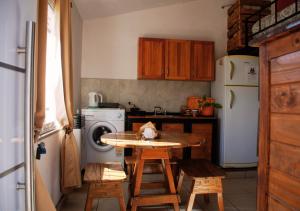 a kitchen with a table and chairs and a refrigerator at LOFT Huayna picchu in La Falda +5 photos