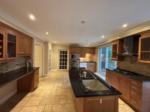 a large kitchen with wooden cabinets and a large sink at House in Markham in Markham