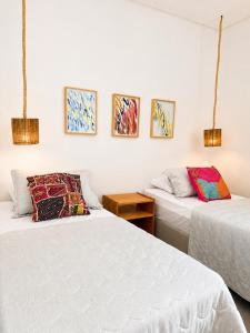 two beds in a room with paintings on the wall at Villa Rita - Preá in Prea +18 photos