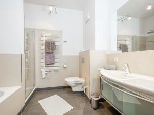 a white bathroom with a toilet and a sink at Saalbach Hinterglemm in Viehhofen
