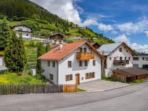 a white house with a red roof on a mountain at Chalet Bergglück in Sellrain