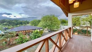 a balcony with a view of a house at Villa Ana Rosa in Jarabacoa