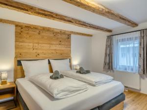 two beds in a room with a wooden wall at Chalet Bergglück in Sellrain