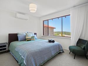 a bedroom with a bed and a chair and a window at Ocean Reef Marina by the Sea 4BR plus Study plus in Perth