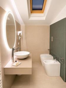a bathroom with a sink and a toilet and a mirror at Valentina Rooms in Bronte