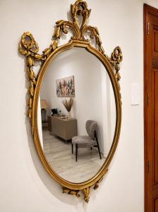 a mirror on a wall with a chair and a desk at Valentina Rooms in Bronte