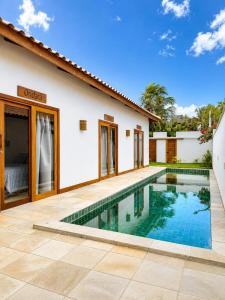 a villa with a swimming pool in front of a house at Villa Rita - Preá in Prea