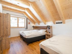 two beds in a room with wooden ceilings at Haus am Bach in Donnersbachwald
