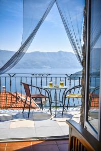 a balcony with a table and chairs and a view of the ocean at Studios Kalina in Budva