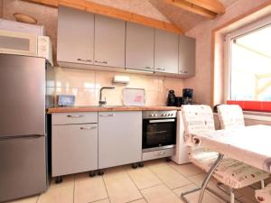 a kitchen with white cabinets and a table with chairs at Am Triensee in Rühn