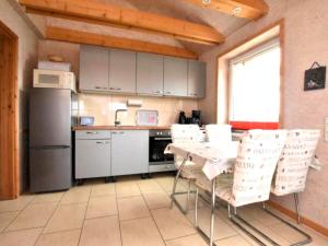 a kitchen with a table and some white chairs at Am Triensee in Rühn +9 photos