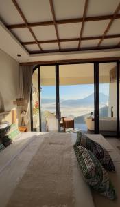 a bedroom with a bed with a view of the ocean at The Casa Lunamoon in Kintamani