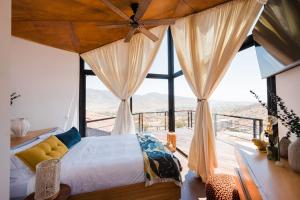 a bedroom with a bed and a large window at Primario Hotel Boutique in Ensenada +196 photos