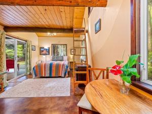 a bedroom with a bed and a table in a room at Charming Tiny Cottage 5 min from National Park in Volcano
