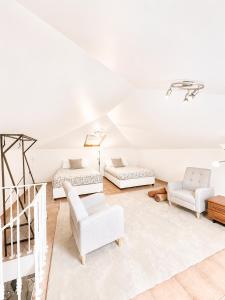 a living room with white furniture and a staircase at Casa Conduto in Ponta do Sol
