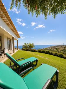 a patio with a table and chairs and the ocean at Casa Conduto in Ponta do Sol