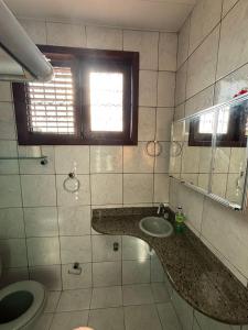 a bathroom with a sink and a toilet and a window at Espaço Cultural Morada in São Luís