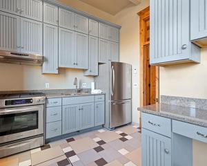 a kitchen with white cabinets and stainless steel appliances at The Kleemann House-1883 Historic Downtown Hotel in Custer