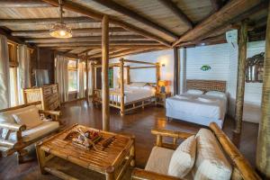 a living room with two beds and a table at Casa Caribe Hotel in Río Dulce +103 photos