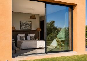 a bedroom with a bed and a sliding glass door at Villa Émeraude 5 Ch in Marrakesh