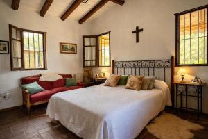 a bedroom with a bed and a cross on the wall at Refugio Serrano con Chimenea y Caballos in San Javier