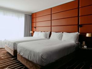 ein Hotelzimmer mit einem großen Bett und einem Fenster in der Unterkunft Mercure Sydney Parramatta in Sydney