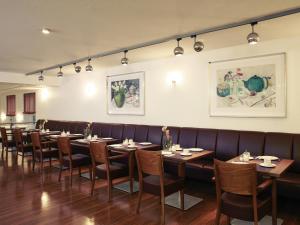a row of tables and chairs in a restaurant at Mercure Hotel am Entenfang Hannover in Hannover