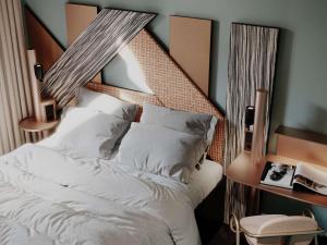a bedroom with a white bed with a wooden headboard at TRIBE Strasbourg Centre Gare in Strasbourg