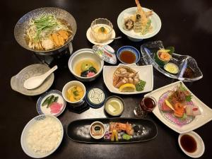 a table with plates of food and bowls of food at Ryokan Ichinomatsu in Hakodate