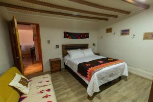 a bedroom with a bed and a couch in it at Casa Sutar Las Higueras in San Pedro de Atacama