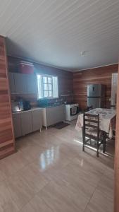 a large kitchen with a table and a bench in it at Otima casa com 2 quartos em Tramandai in Tramandaí