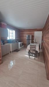 a large room with a kitchen with a table in it at Otima casa com 2 quartos em Tramandai in Tramandaí +3 photos