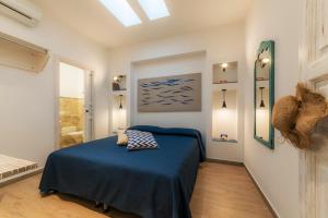 una camera da letto con un letto con una coperta blu di Timbuktu Hostel a San Vito lo Capo