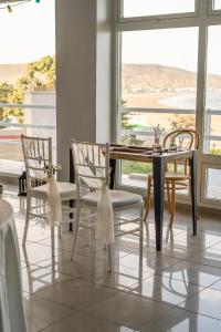 a dining room with a table and chairs and a window at Apart Hotel Ostrón in Rada Tilly