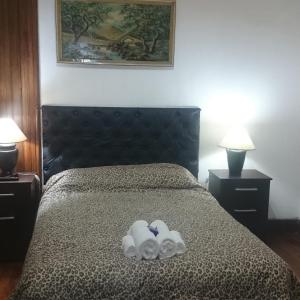 a bedroom with a bed with two towels on it at Hostel Marino Rosario in Rosario